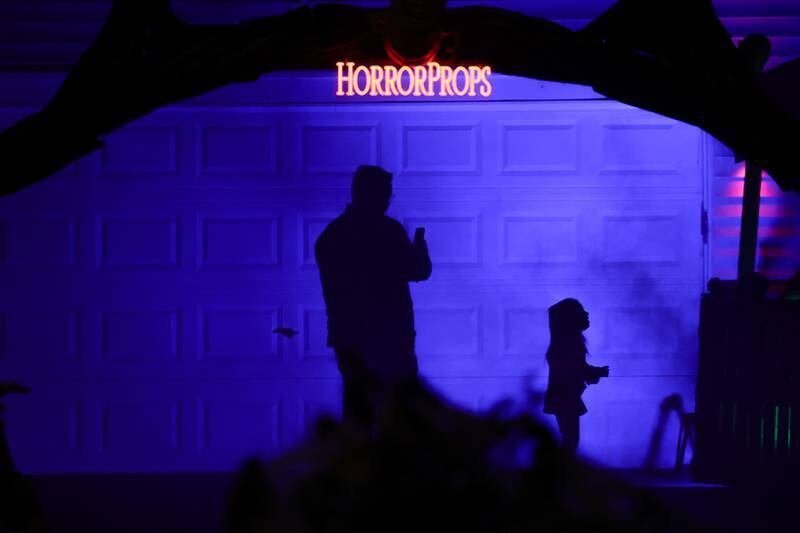A father brings his daughter to see the newest Halloween display by Dave Appel HorrorProps, who made national attention with his “Stranger Things” display, on Thursday, Oct. 17, 2024 in Plainfield.