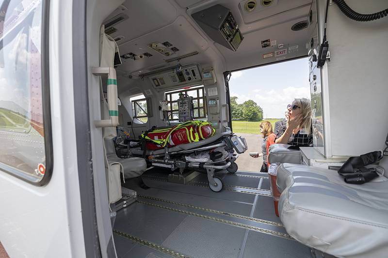 Abby Weber, Executive Director of the KSB Hospital Foundation, peeks inside of the OSF Life Flight helicopter  Wednesday, July 10, 2024 during an open house at their new hangar in Rock Falls.