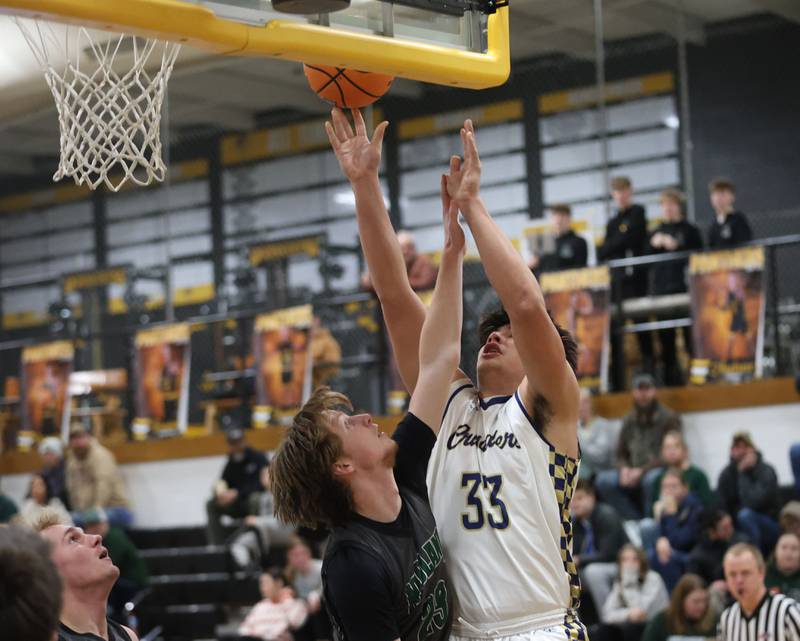 Marquette's Blayden Cassel lets go of a shot under the hoop over Midland's Luke MCcullough during the Tri-County Conference Tournament on Monday, Jan. 26, 2026 at Putnam County High School
