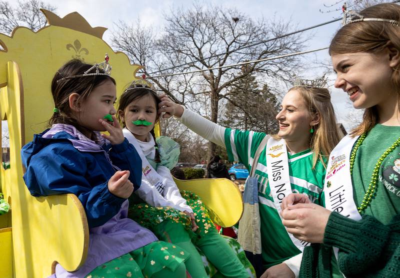 Emily Graf (11), right, and Stephanie Corona, middle right, help Parker Nguyen (5), middle left, and Freya Hadap (4) with their hair and mustaches before the St. Charles St. Patrick’s Parade on Main Street in St. Charles on Saturday, March 15, 2025. The group was part of the Miss Northern Suburbs Organization which is affiliated with the Miss Illinois and Miss American Pageants.