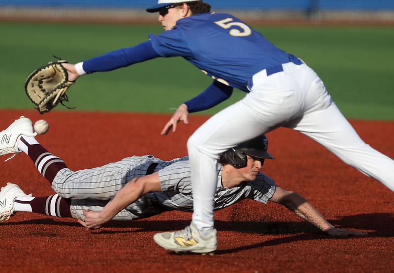 Richmond-Burton's Colton Schwind dives bask to first base as Johnsburg's Nate Frost tries to come up the throw during a Kishwaukee River Conference baseball game on Monday, April 6,2026, at Johnsburg High School.