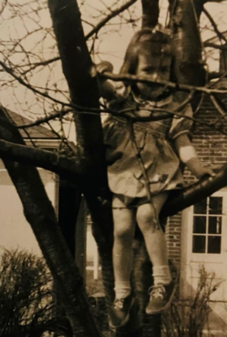 Deborah McGrath sitting in a cherry tree in her Lombard home, circa 1954.