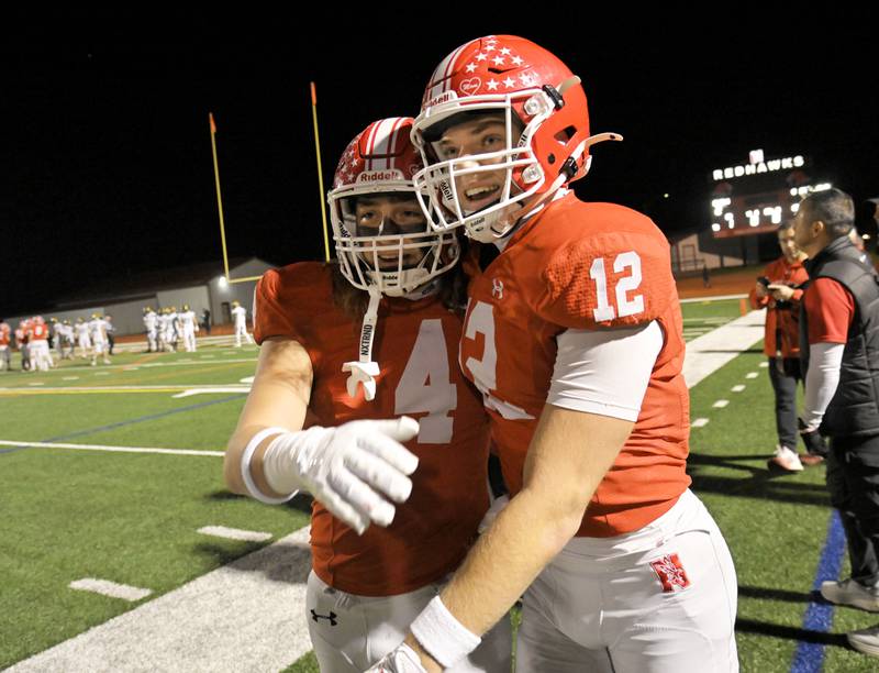 Naperville Central’s Garrett Nichols, right, is congratulated by teammate Aaron Nussbaum after his catch gave the Red Hawks a three-touchdown lead against Fremd in a IHSA Class 8A second round playoff game in Naperville on Friday, Nov. 8, 2024.