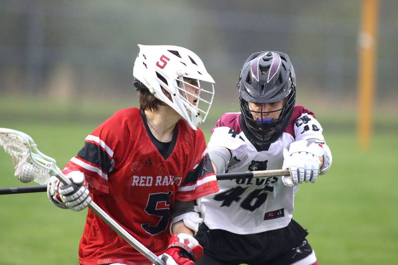 Huntley’s Nick Toman, left, looks for an option as  Prairie Ridge’s Hudson Giglio defends in varsity boys lacrosse at Prairie Ridge  High School in Crystal Lake on Thursday, May 1, 2025.