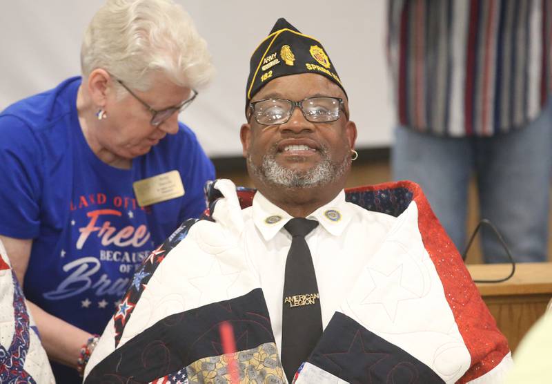 Spring Valley Veteran Clifton Cradle, smiles receives his quilt from Betty Baznik during the Quilt of Valor ceremony on Saturday, April 19, 2025 at the Moose Lodge in Princeton.
