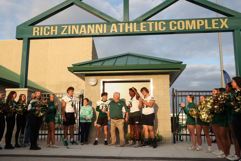 Athletes, alumni and attendees cheer after Rich Zinanni, center, cut the ribbon at Bishop McNamara's new Rich Zinanni Athletic Complex on Thursday, Aug. 21, 2025.