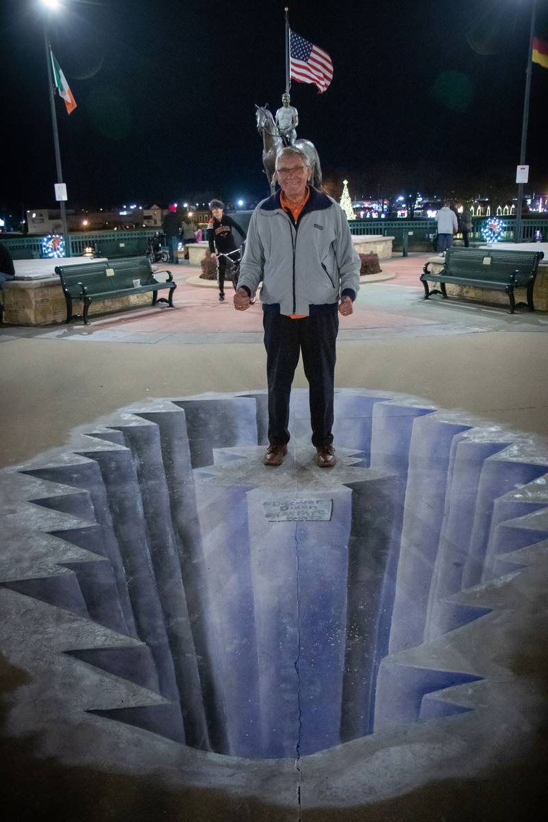 Larry Reed of Dixon stands at the edge of a cliff painted by Nora Balayti of Dixon during the Dixon Christmas Walk Friday, Dec. 2, 2022.