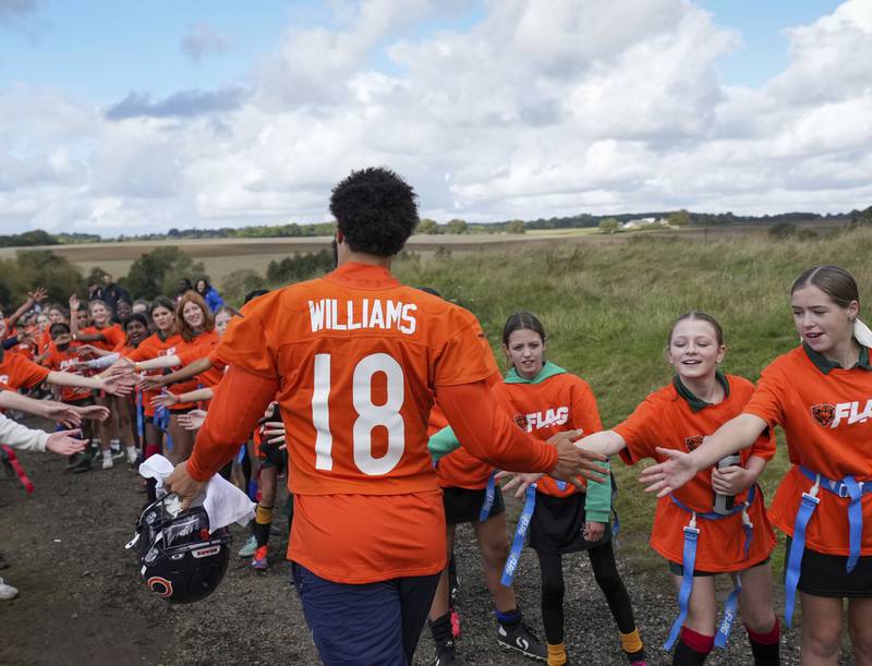 Chicago Bears quarterback Caleb Williams (18) walks through an honor gauntlet made up of British school children who were attending a Bears community event. During a training session in Ware, England, Thursday, Oct. 10, 2024, ahead of the game between the Chicago Bears and the Jacksonville Jaguars at Tottenham Hotspur Stadium on Sunday. (AP Photo/Sean Ryan)