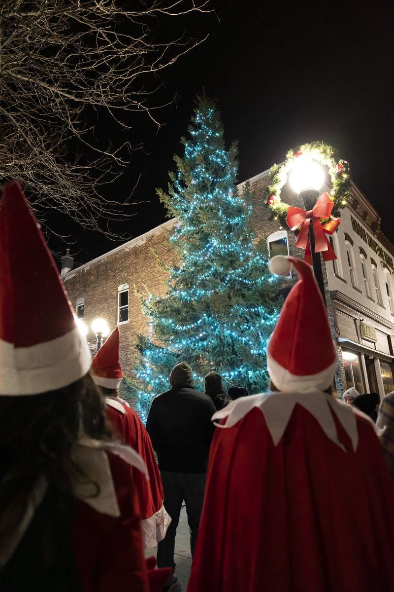 The Christmas tree in Spring Valley's Mini Park is lit Saturday, Nov. 26, 2022, as Elf on the Shelf float participants look on.