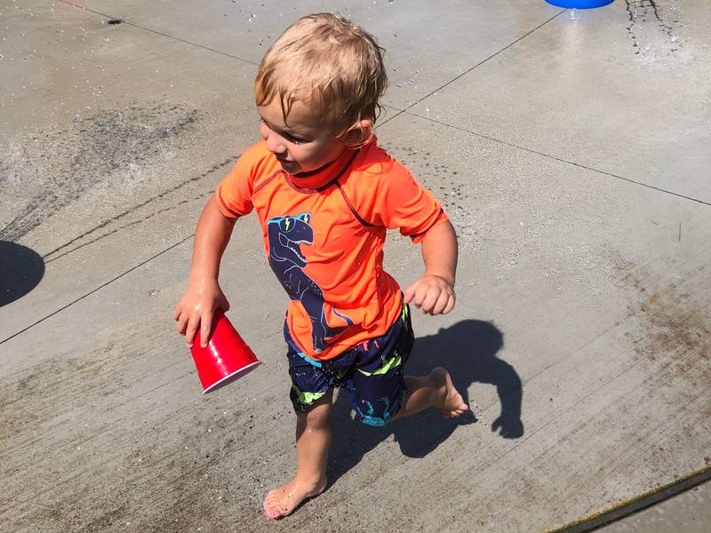 Bodie Graf, age 2, of Lakemoor plays with a solo cup at the splash pad at Whispering Oaks Park in McHenry Wednesday. The heat index climbed to well over 100 degrees.