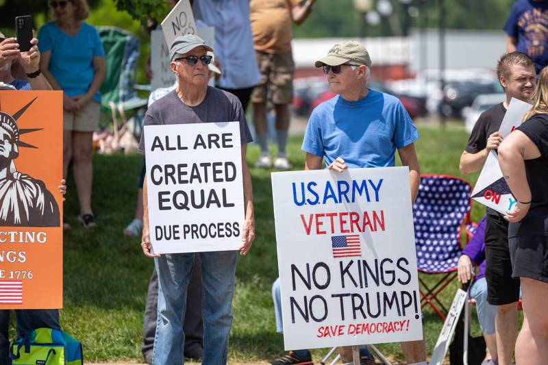 Protesters hold signs at the “No Kings” protest on Saturday, June 14, 2025 at Rotary Park in Princeton.
