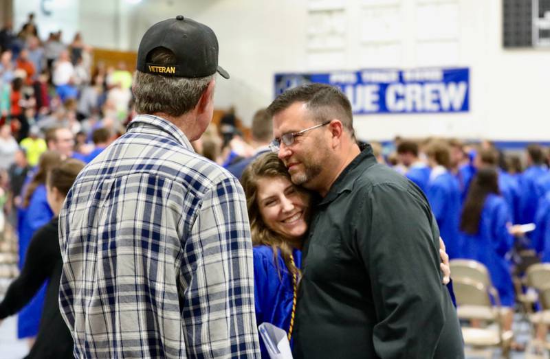 PHS graduate Taylor Wetsel receives a hug from her dad, Gary, along side her grandpa, Jerry Fisher, after Saturday's graduation ceremonies at Prouty Gym.