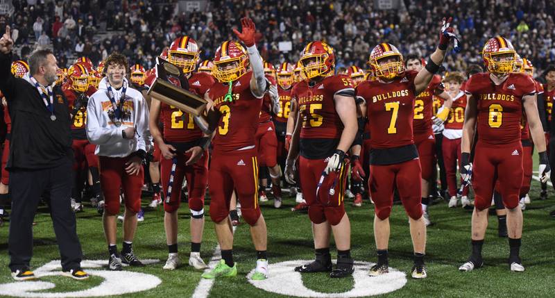 Joe Lewnard/jlewnard@dailyherald.com
Batavia's Ryan Whitwell (3) holds the second-place trophy alongside fellow captains following the bulldogs 44-20 loss to Mount Carmel during the Class 7A football state title game at Memorial Stadium in Champaign on Saturday, Nov. 26, 2022.