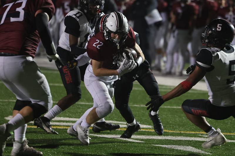 Plainfield North’s John St. Clair powers his way for extra yards against Rich Township in the 1st round of the playoffs on Friday.