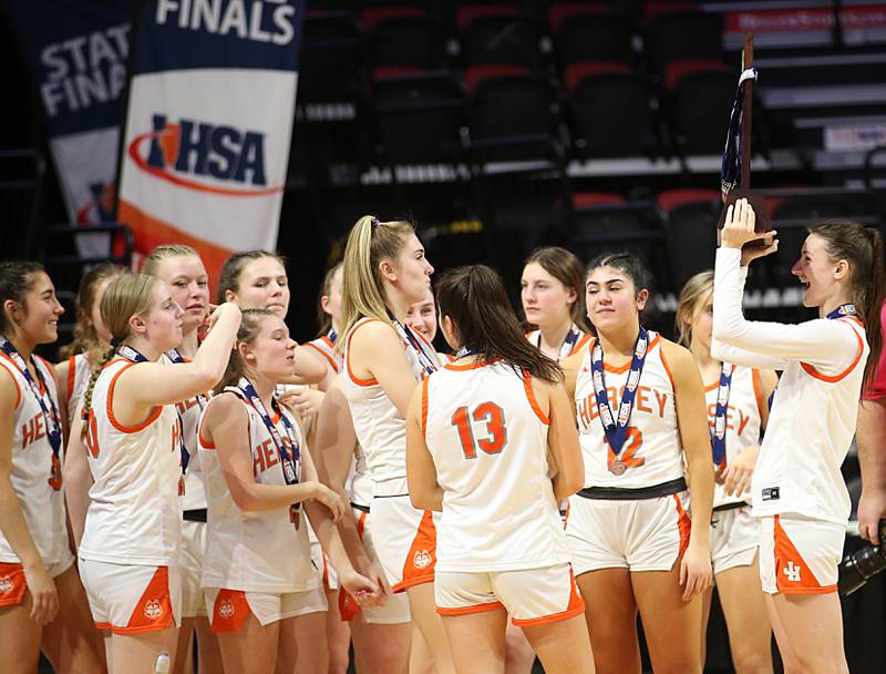 Members of the Hersey girls basketball team hoist the Class 4A State trophy after loosing to Geneva during the third place game on Friday, March 3, 2023 at CEFCU Arena in Normal.