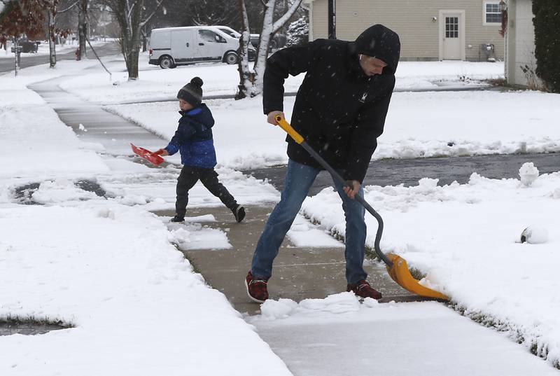 Liam Murray, 5, helps his dad, Cory, shovel the sidewalk in front of their home on Talisman Drive in Crystal Lake as a winter storm moves through McHenry County on Tuesday, Jan. 9, 2024, delivering snow to most of the county.