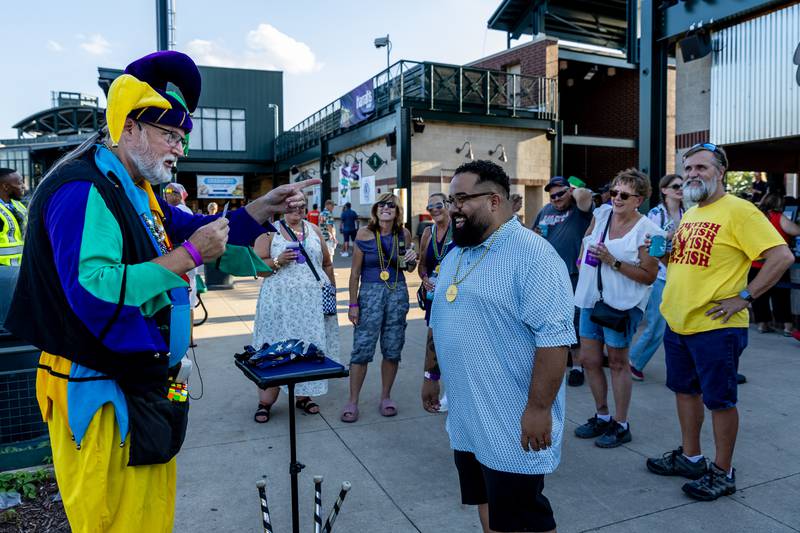 Keith Cobb performs a card trick for Joliet resident Eddie Perez during New Orleans North Festival at Joliet Slammers Stadium on Aug. 15, 2025.