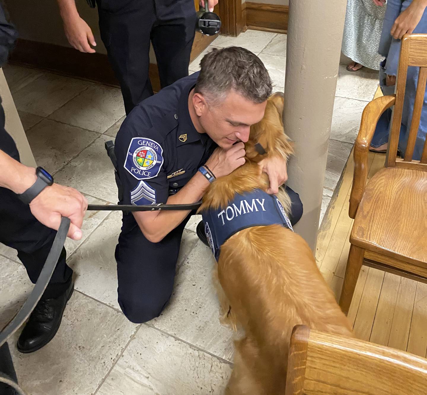 Geneva Sgt. Brad Jerdee gives the city's new comfort dog, Tommy, a hug. Community Service Officer Brad Koontz presented the 18-month-old golden retriever at a special Committee of the Whole June 23, 2025.