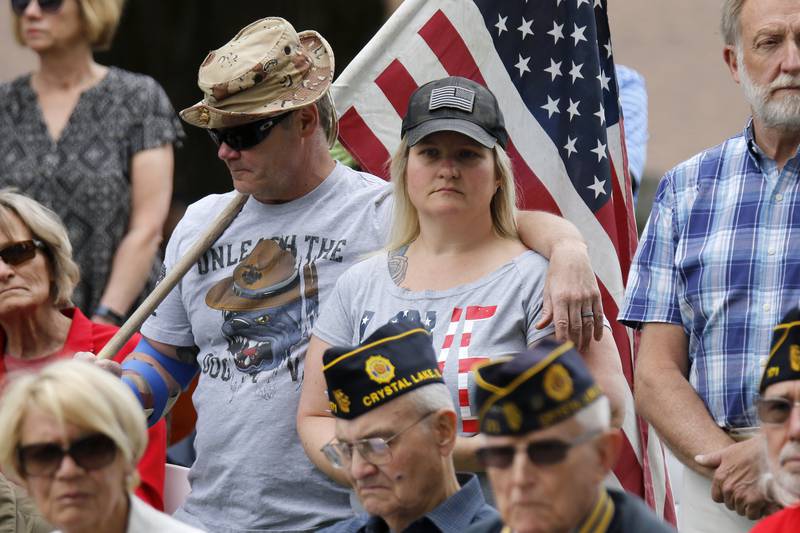 Police officer and former Marine Tim Mitsven and wife Tiffany listen to the Memorial Day ceremony on Monday, May 31, 2021 in Crystal Lake. The parade began at Crystal Lake Central High School and continued through downtown, ending at Union Cemetery with a ceremony.