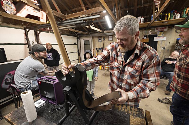 Jason Stephens presents Kris Riggen, 10, of Dixon with his new guitar Thursday, Dec. 7, 2023. Stephens and friends renovate and donate instruments a couple times a month to any aged kid who wants to learn to play.