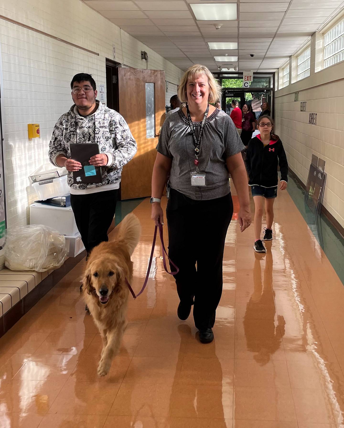 New Plainfield Academy Principal Karyn Holstead and service dog Leroy walk the hall on the first day of school on Thursday, August 18, 2022. Holstead became the school's new leader after being its assistant principal for six years.