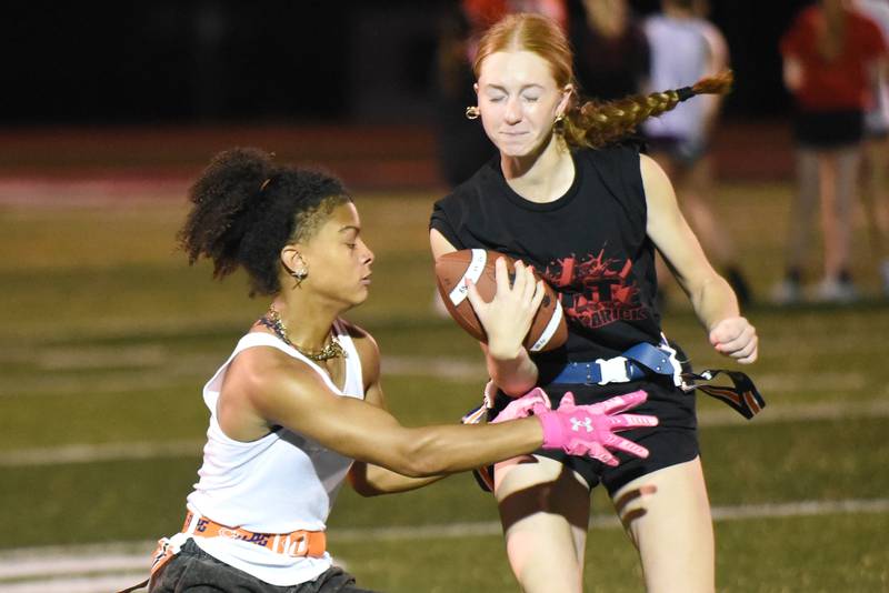 Bradley-Bourbonnais' Nevaeh Brown, left, looks to pull a flag from Bristol Schriefer during the first day of girls flag football practice Monday, Aug. 11, 2025.