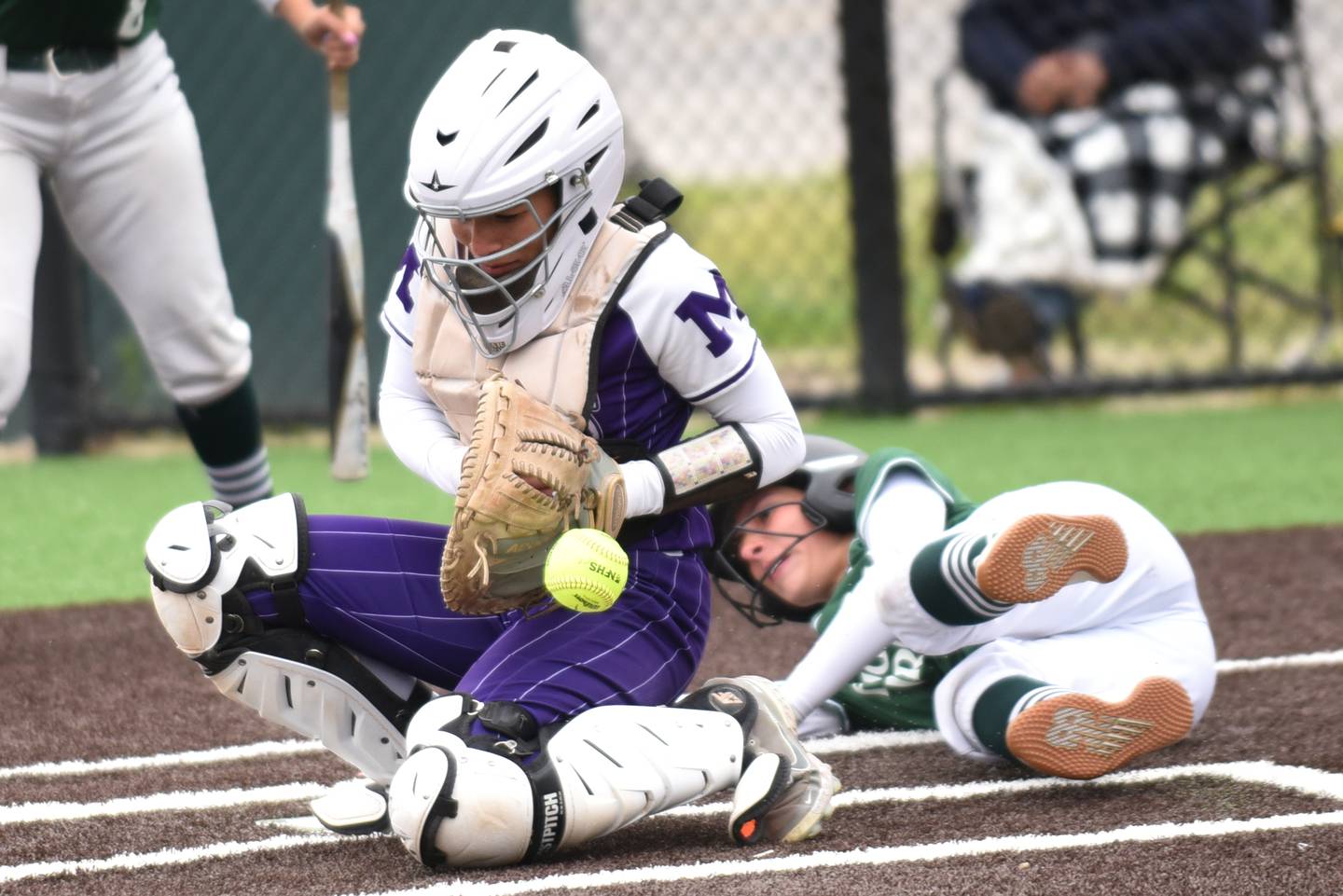 Manteno catcher Jaz Manau, left, knocks down a late throw to home plate after Bishop McNamara's Analeah Ramirez slid in for a run in the ninth inning of the Class 2A Coal City Sectional semifinals Wednesday, May 21, 2025.