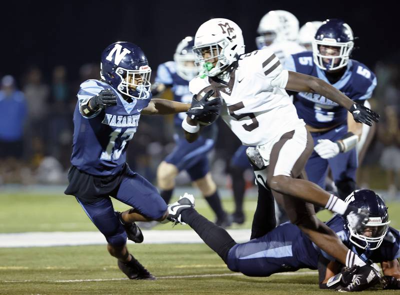 Mt. Carmel's Jamari Brown (5) attempts to run past Nazareth's Yandiel Colon (13) during the varsity football game between Mt. Carmel high school and Nazareth Academy on Friday, Sept. 12, 2025 in La Grange Park, IL.