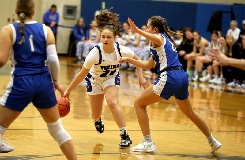 Geneva’s Kinsey Gracey (center) dribbles between a pair of Wheaton North defenders during a game at Geneva on Friday, Dec. 22, 2023.