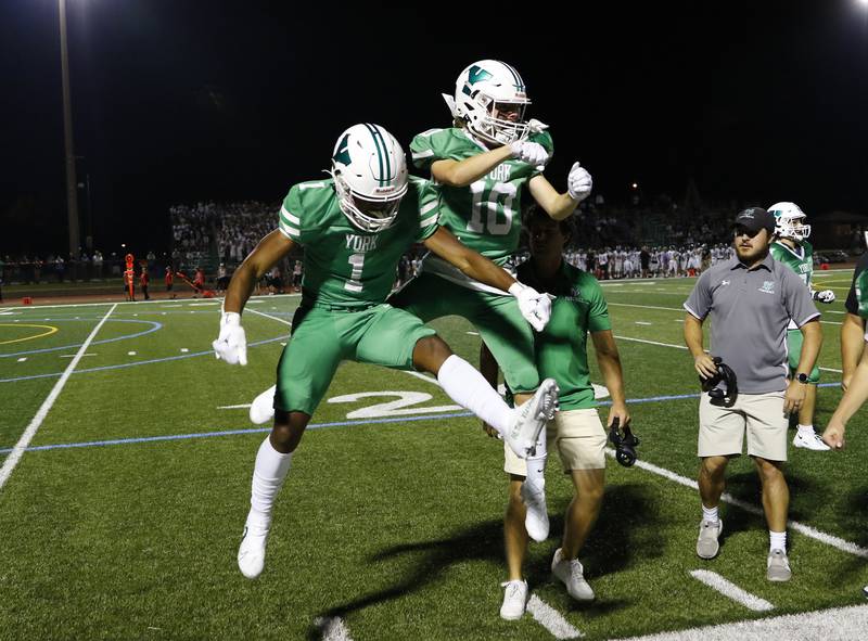 York's Kelly Watson (1) celebrates a touchdown with Brian Grant (10) during the boys varsity football game between Downers Grove North and York on Friday, Sept. 16, 2022 in Elmhurst, IL.