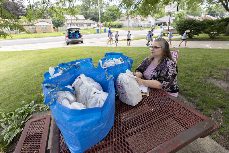 Summer Eats volunteer Tina Adcock waits to hand out lunch items Wednesday, July 16, 2025, at Lincoln School in Dixon. It doesn’t take long for Adcock to hand out all 40 bags of food.