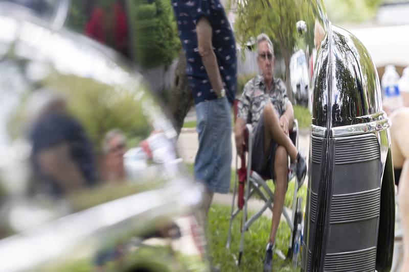 Steve Snitchler of Dixon is seen reflected in his own 1948 Ford Super Deluxe Friday, July 5, 2024 at the Petunia Fest car show.