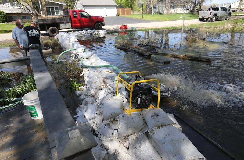 Volunteers work to protect a home in Holiday Hills  as flooding continues on the Fox River on Wednesday, April 22, 2026.