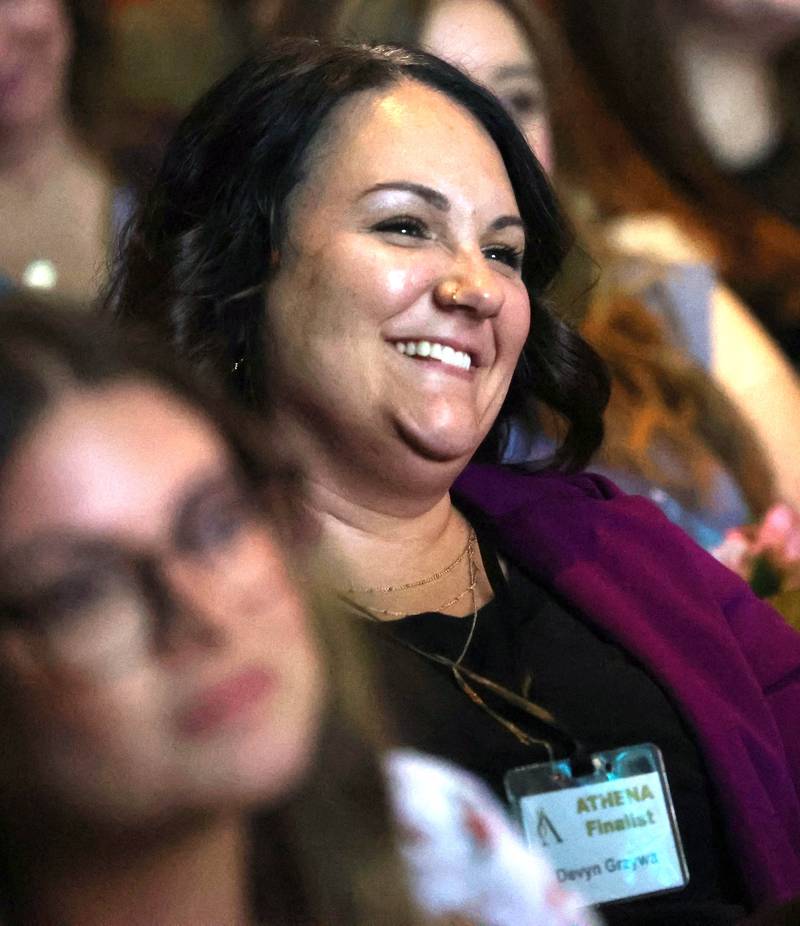Devyn Grzywa, an Athena Award finalist, smiles as she listens to her presenter Amy Oster talk about her and why she is deserving to be nominated Thursday, Oct. 16, 2025, during the 35th annual Athena and Women of Accomplishment Award Reception at the Egyptian Theatre in DeKalb.