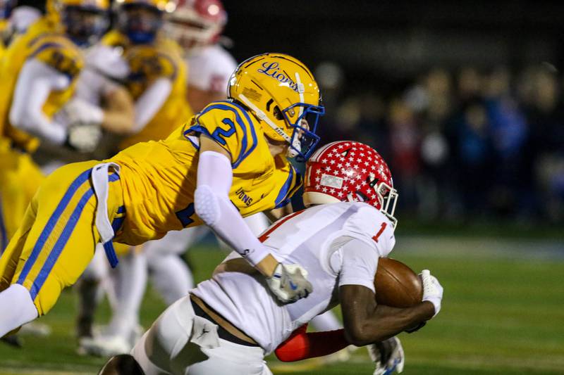 Lyon's Travis Stamm (2) defends a short pass Naperville Central's DeShaun Williams (1) during Class 8A quarterfinal football game between Naperville Central at Lyons on Friday, Nov 15, 2024  in Western Springs.