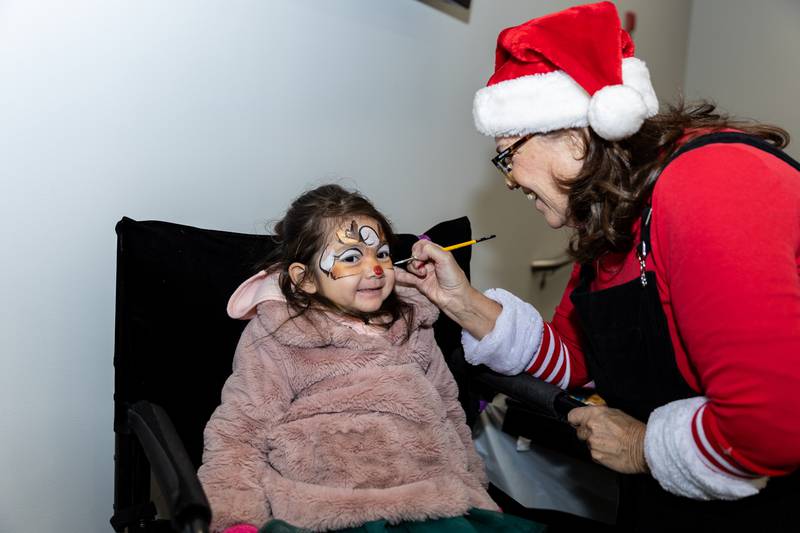 Crest Hill resident Emmy Silva gets her face painted by Donna Chlumsky of Sparkles Entertainment during Winterfest at Crest Hill City Center on Nov. 30, 2024.