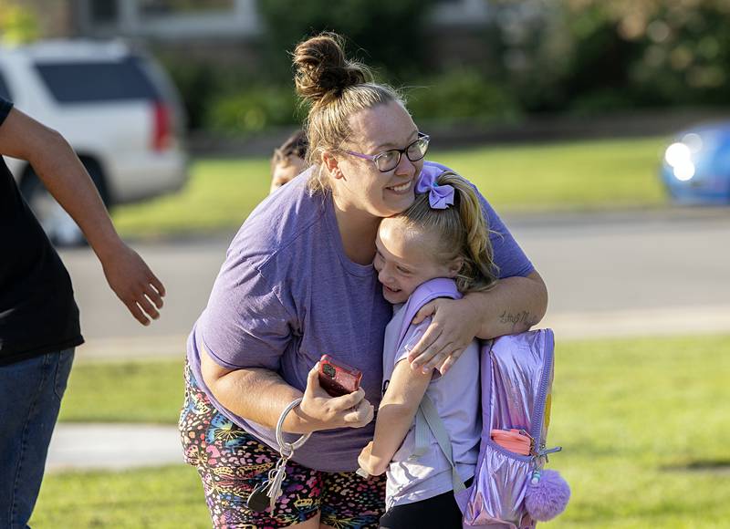 First grader Letty Johnson of Dixon gets one last hug from mom Shantel before heading off to school at Washington Wednesday, Aug. 14, 2024.