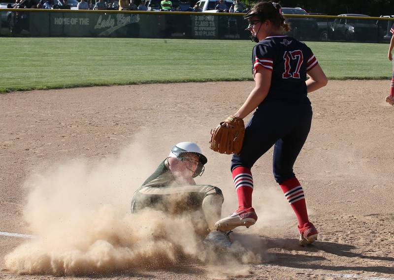 St. Bede's Madelyn Torrence plows into third base while the ball gets away from Biggsville's Ashley Meyer in the Class 3A Sectional championship game on Friday, May 26, 2023 at St. Bede Academy.