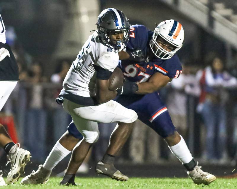 Oswego senior defensive lineman Andrew Shaw (97) tackles an Oswego East player during a game this season.