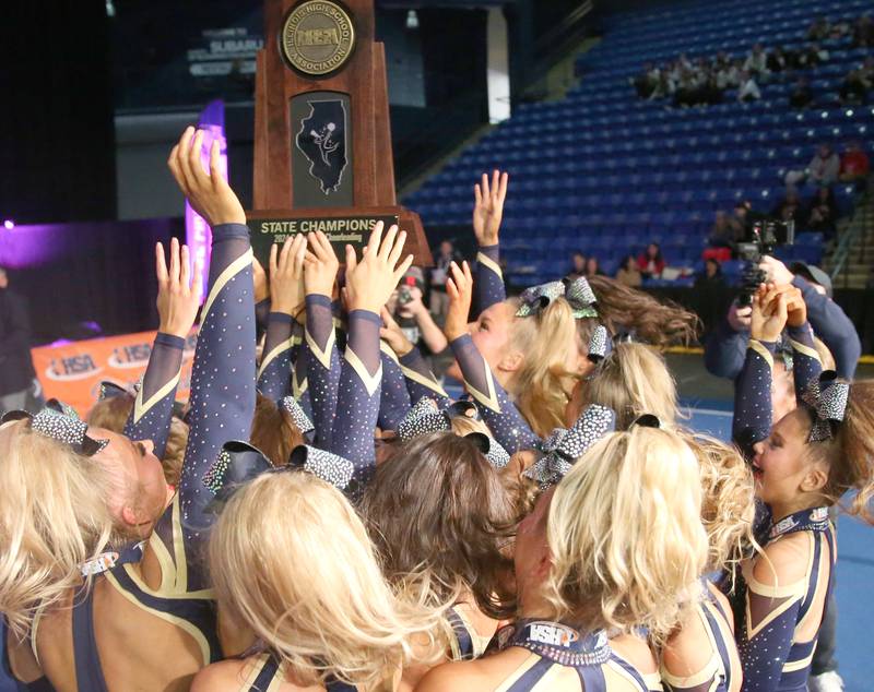 Members of the Lemont heerleading team hoist the first-place trophy after winning the medium team division at the Competitive Cheerleading State Final Competition on Saturday, Feb. 3, 2024 at Grossinger Motors Arena in Bloomington.