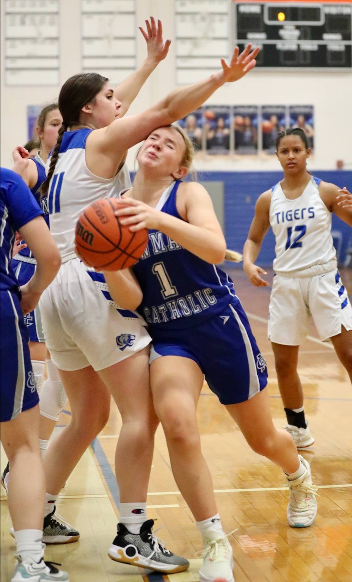 Newman's Jess Johns dips under Princeton's Olivia Gartin for a shot Monday night at Prouty Gym.