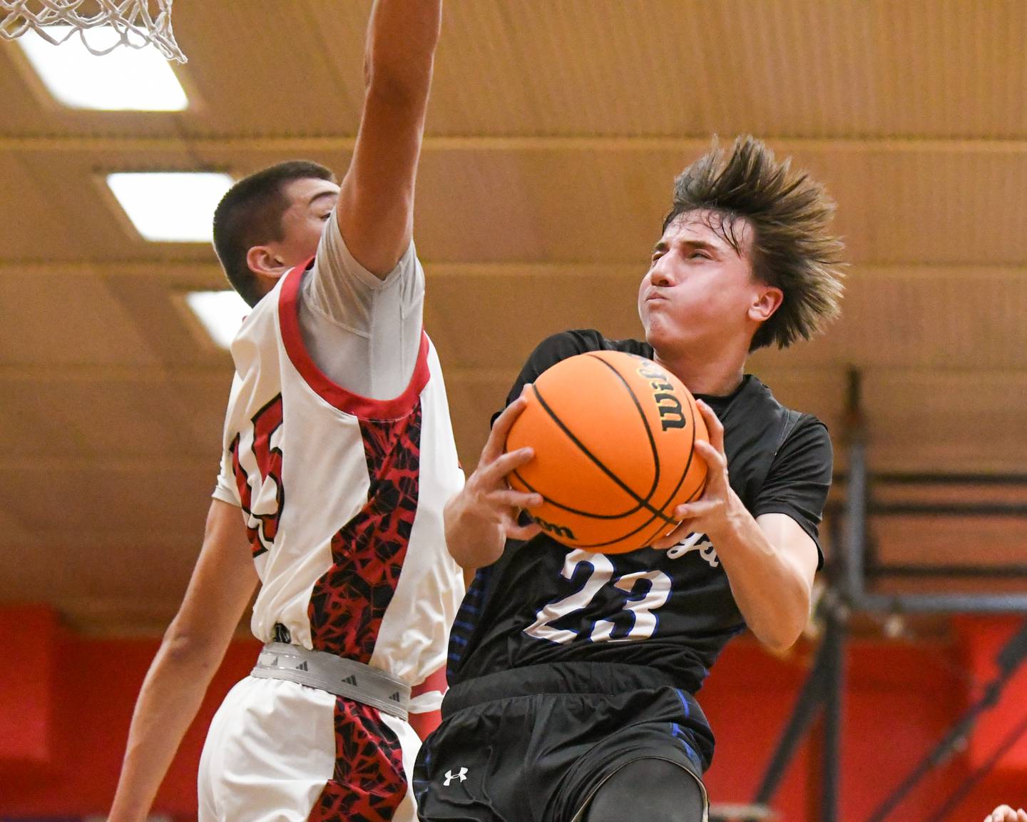 Riverside Brookfield's Noah Van Tholen (23) goes up for a shot during the game while being defended by Glenbard East's Jacob Marynowski (15) on Friday Dec. 19, 2025, held at Glenbard East High School.