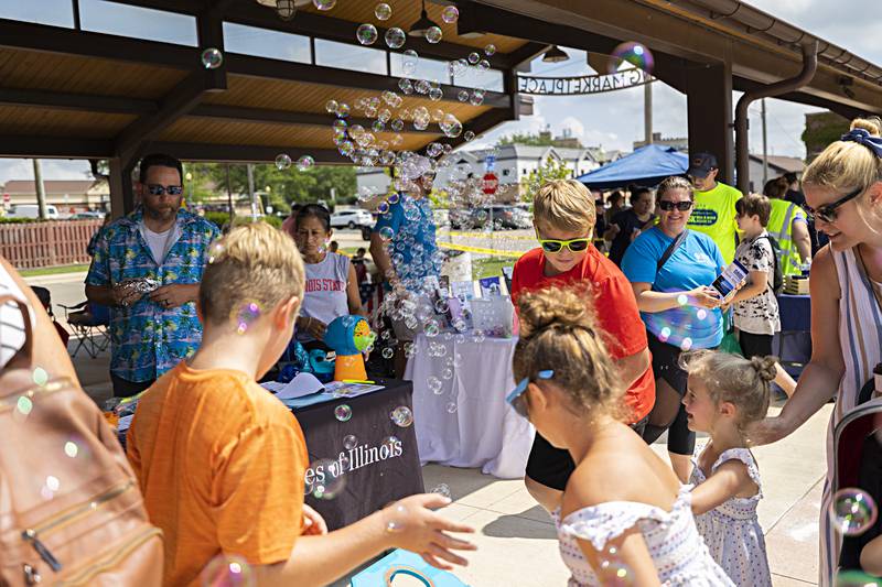 Bubbles fill LSSI’s booth at the Sterling Market Place Friday, August 4, 2023. Over 90 BLIND leaders and 12 impact members helped the 25 vendors who attended the family fun fair and Hot Dog Days.