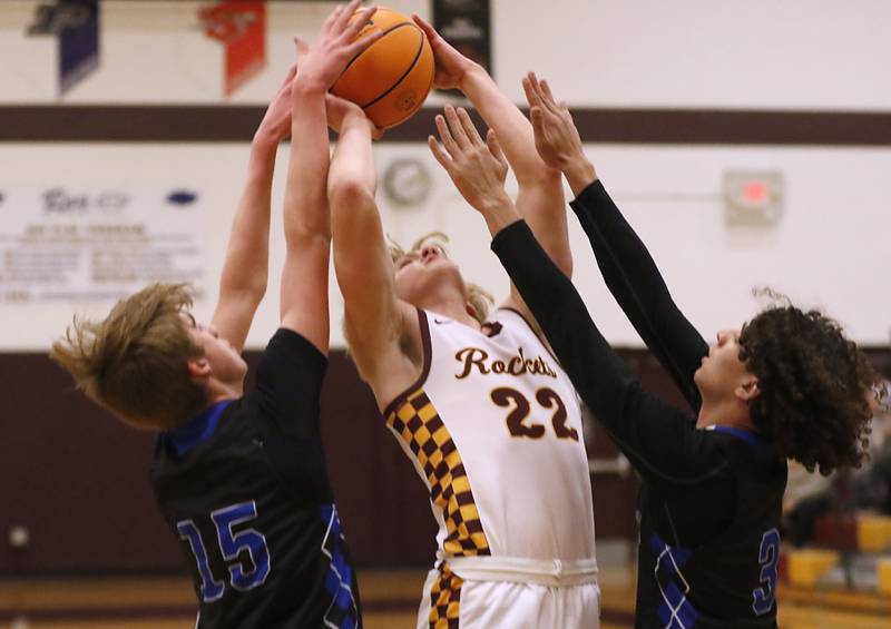 Richmond-Burton's Ryan Wisniewski (center) tries to force a shot up between Woodstock's Liam Laidig (left) and Jeremy Stokes (right) during a Kishwaukee River Conference basketball game on Wednesday, Feb. 5, 2025, at Richmond-Burton High School.