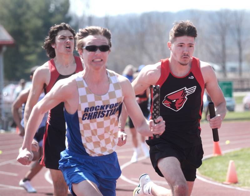 Forreston's Jonathan Milnes (left) cheers on Noah Dewey after handing him the baton as they race against Rockford Christian's Cameron Johnson in the final leg of  the 4x100 relay at the Gebhardt-Worley Invitational at Oregon High School on Saturday, April 12, 2025. The Cardinals finished second in the event at 44.68 seconds. Lena-Winslow won the race with a time of 43.69. Rockford Christian was third in 45.10.