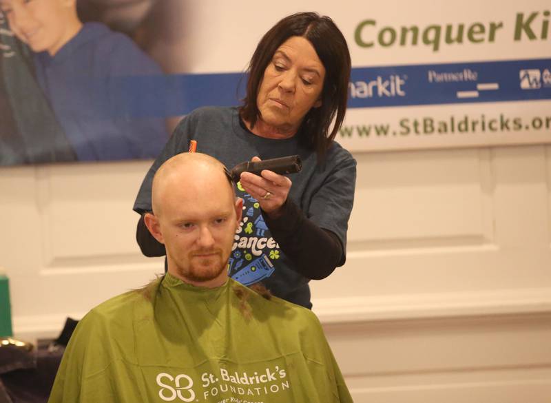 Jesse Briet, has his head shaved by beautician Jennifer Stoneking, owner of Utica Hair Company, during the 18th annual Illinois Valley Emergency Services St. Baldrick's event on Sunday, March 23, 2025 at Senicas Oak Ridge in La Salle.