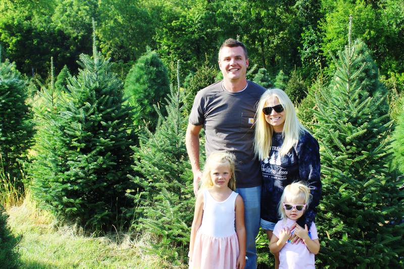 The Strom Family of Dixon – Sam and Laura, and their children Evie (left) and Grace – enjoys the holiday senses that come with a real Christmas tree, such as the scents of the needles and touches of twigs, and they grow them on their local farm.