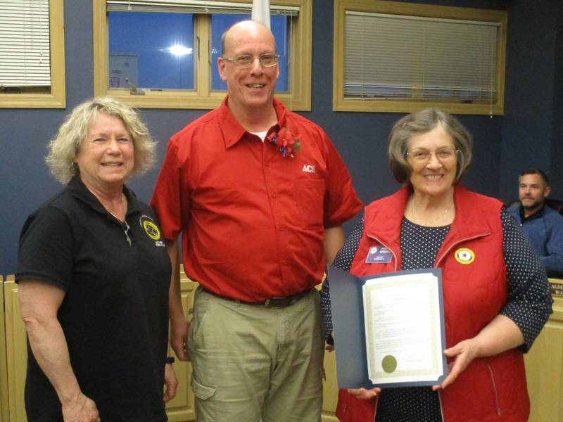Joanne Leibold of the Yorkville American Legion Post 489 Auxiliary displays a proclamation from Yorkville Mayor John Purcell, center, declaring May 9 to 15 as Poppy Awareness Days. At left is Auxiliary President Diane Dillow. Looking on from his seat is Alderman Jason Peterson. (Mark Foster -- mfoster@shawmedia.com)