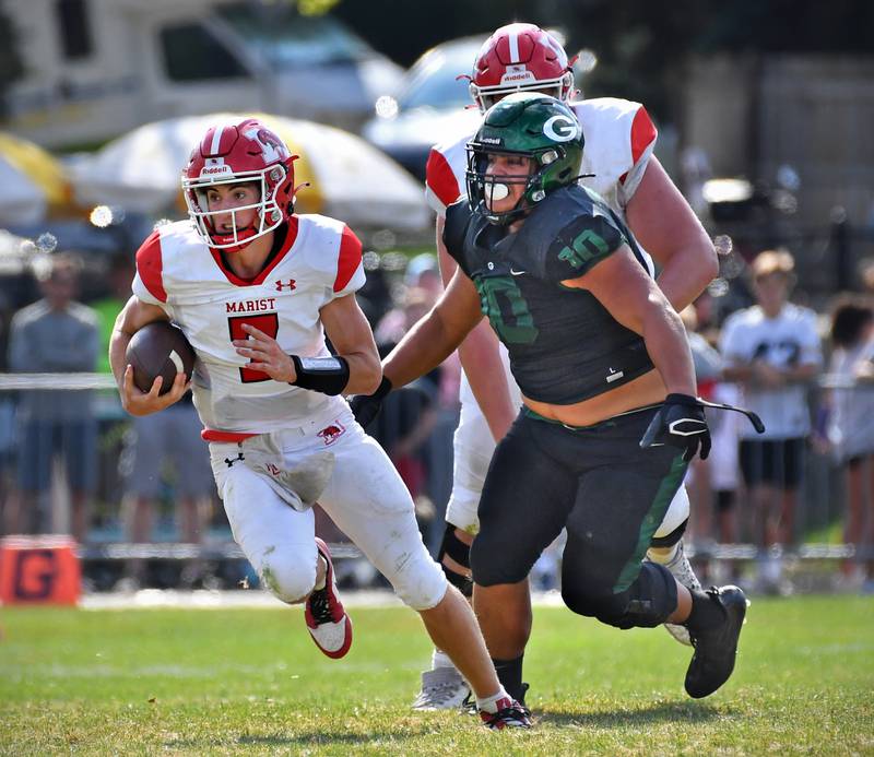 Marist quarterback Owen Winters (7) takes off on a run as Glenbard West's Danny Coffey (10) gives chase during a game on Aug. 26, 2023 at Glenbard West High School in Glen Ellyn.