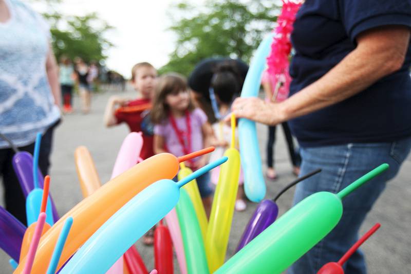 Library Executive Director Sarah Tobias makes balloon animals and shapes for the children at Sycamore Library's first beach party on Friday, August 1, 2014.